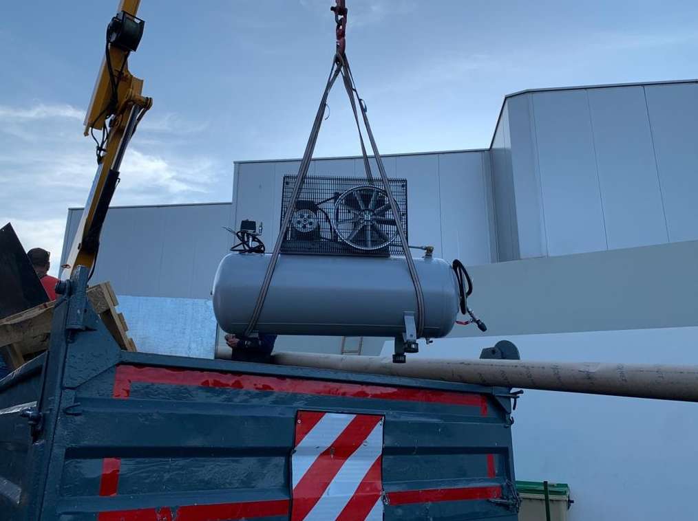 grua elevando compresor de aire